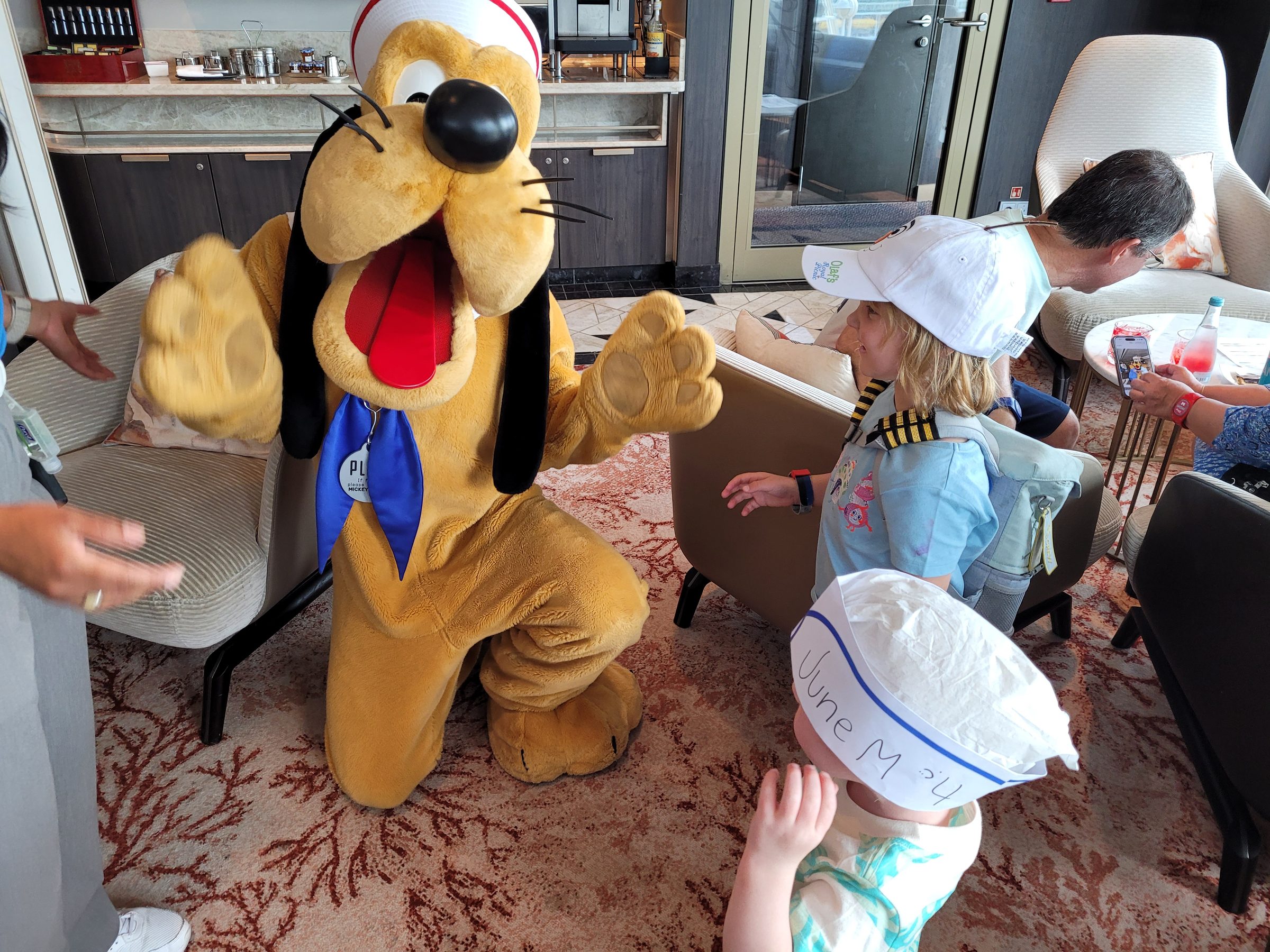 Pluto visiting the kids in the Disney Wish concierge lounge