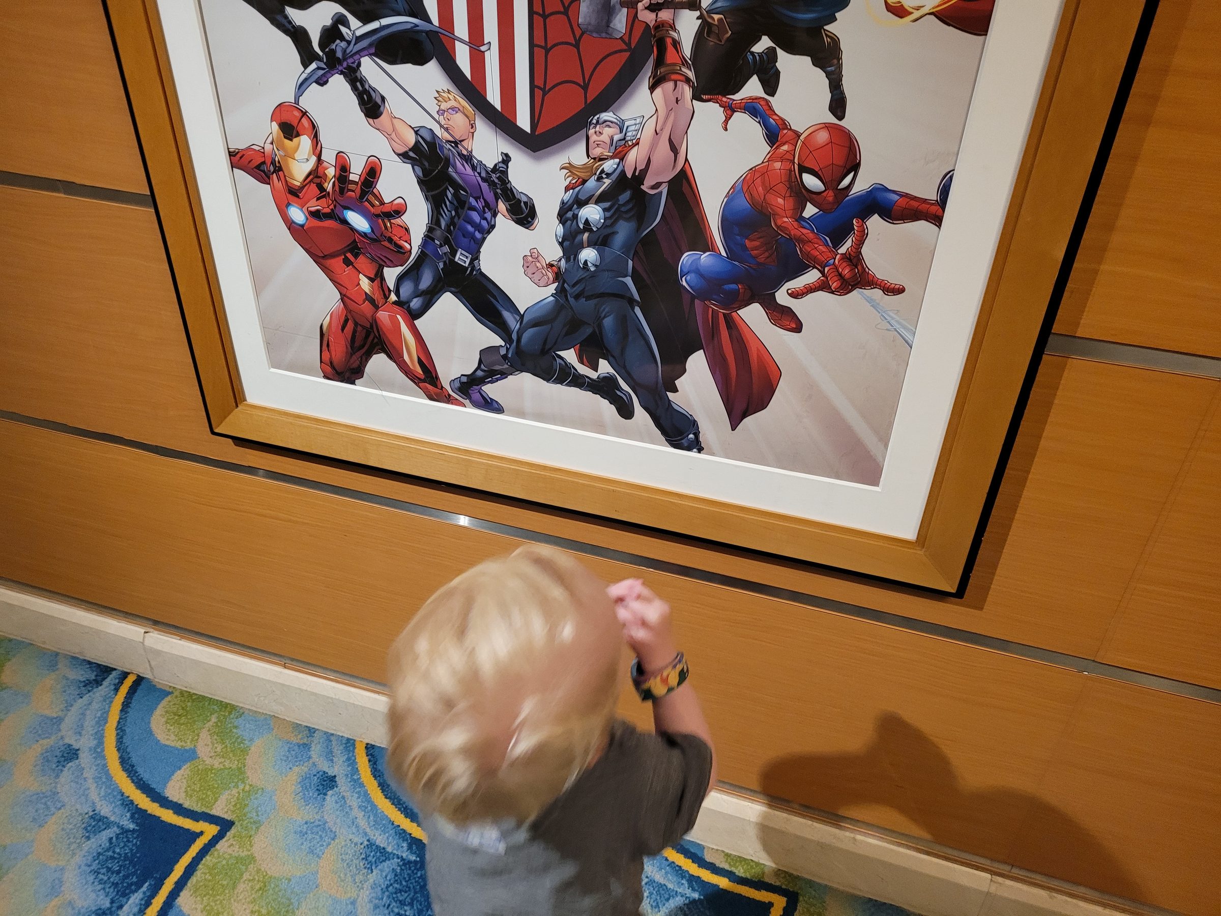 Raccoon pointing at an Avengers poster